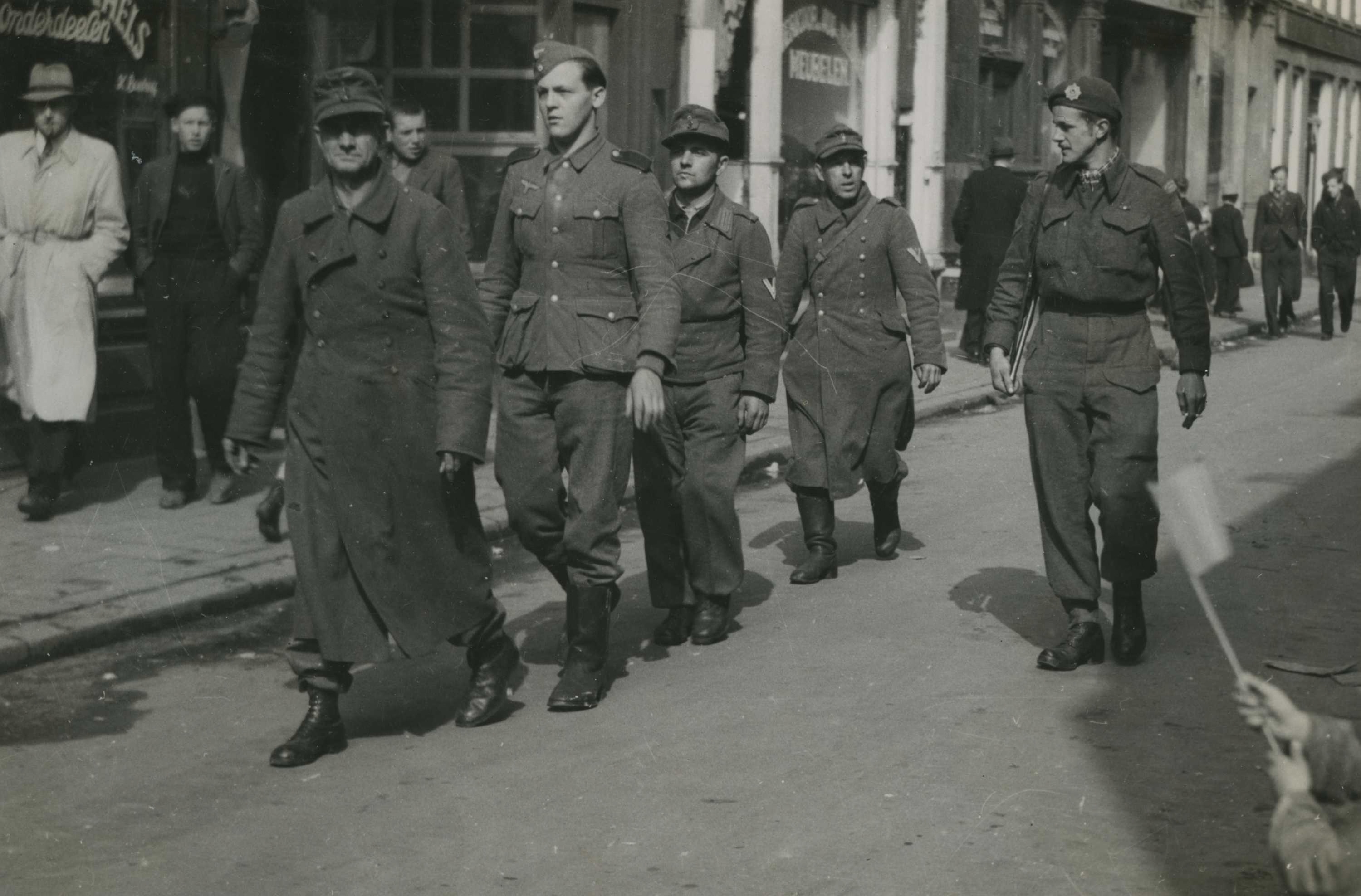 Duitse krijgsgevangenen met een Canadese militair na de bevrijding van Groningen.