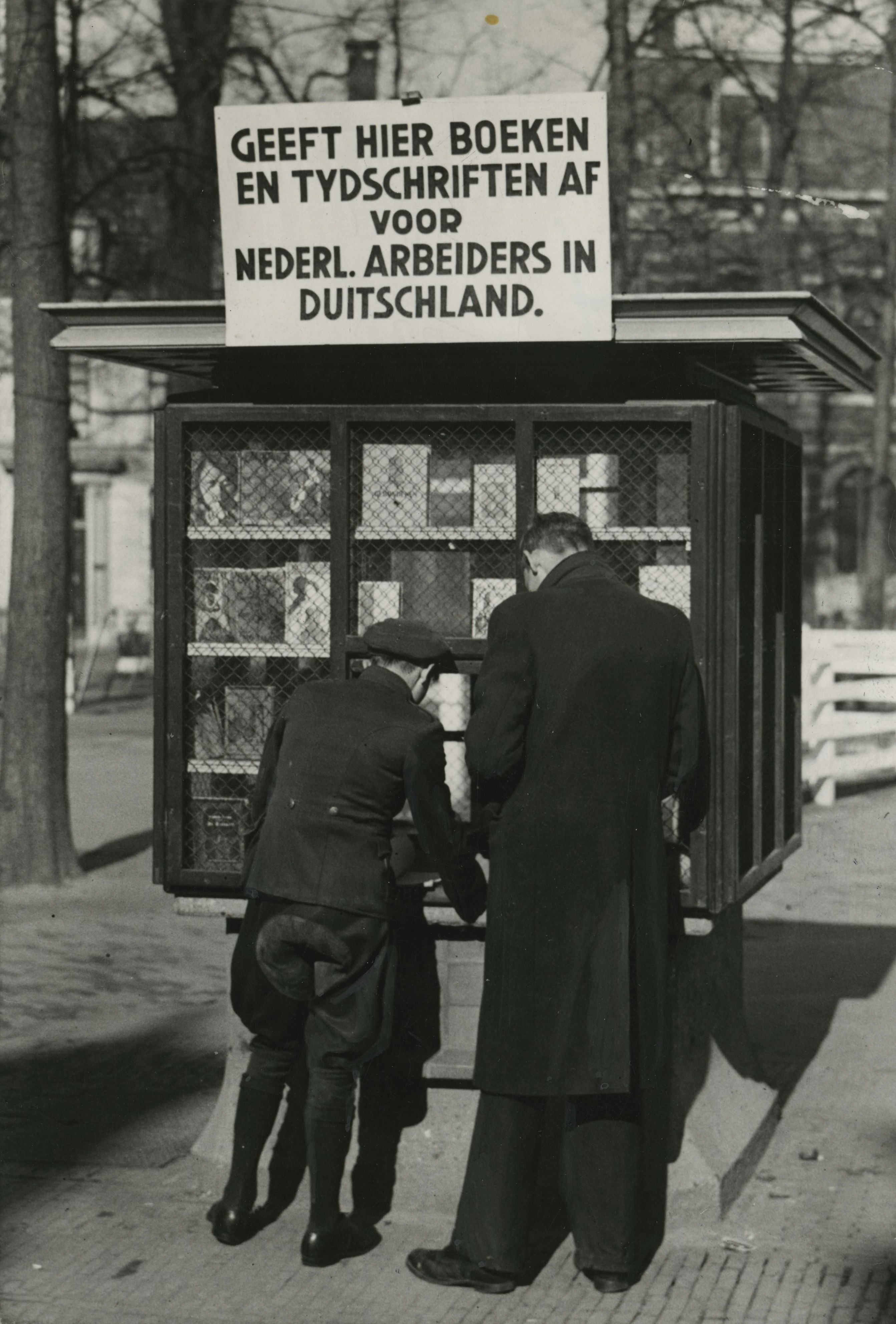 Foto van een kiosk waar boeken en tijdschriften kunnen worden gedoneerd aan Nederlandse arbeiders in Duitsland