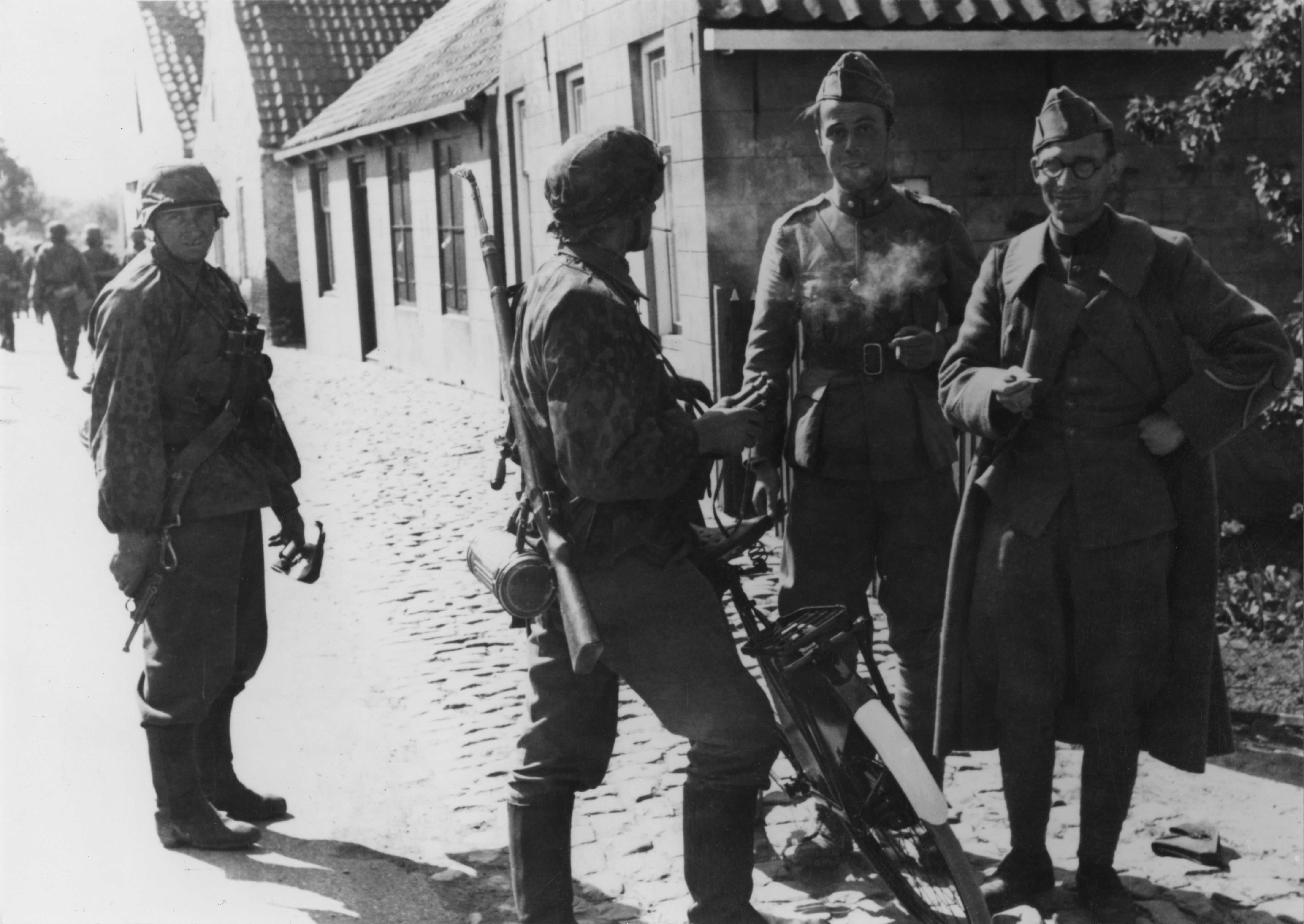 Waffen-SS'er van het Regiment Deutschland praat met twee ontwapende Nederlandse militairen op 17 mei 1940 in Kapelle