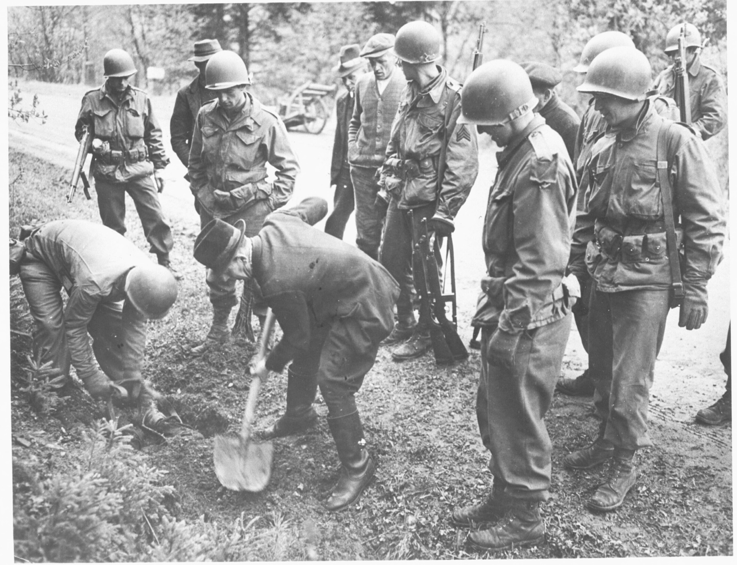 Amerikaanse militairen dwingen Duitse burgers om slachtoffers van een dodenmars op te graven bij Kamp Flossenbürg