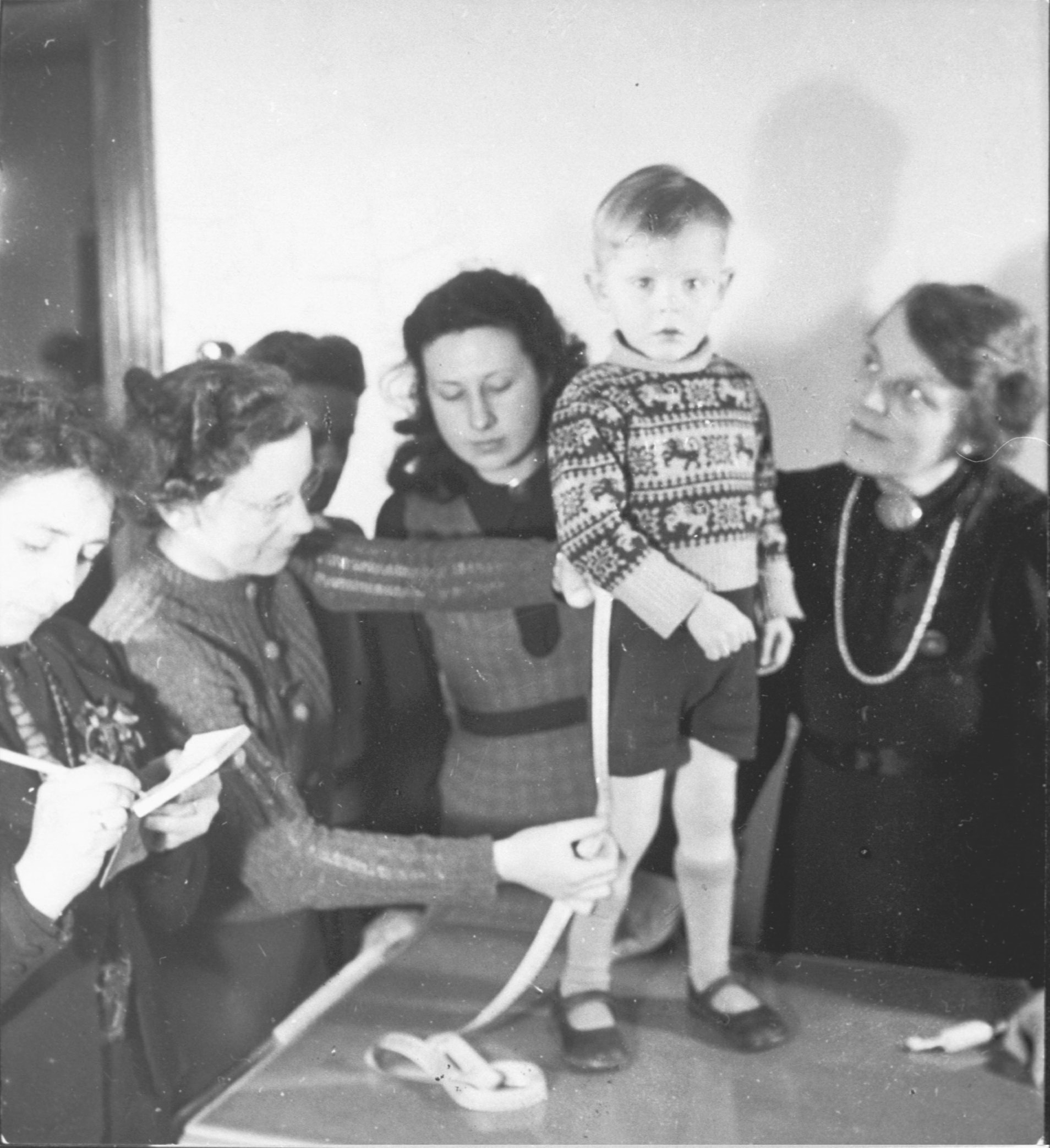 Vrouwen van de NSVO nemen de maat op voor het maken van een korte broek