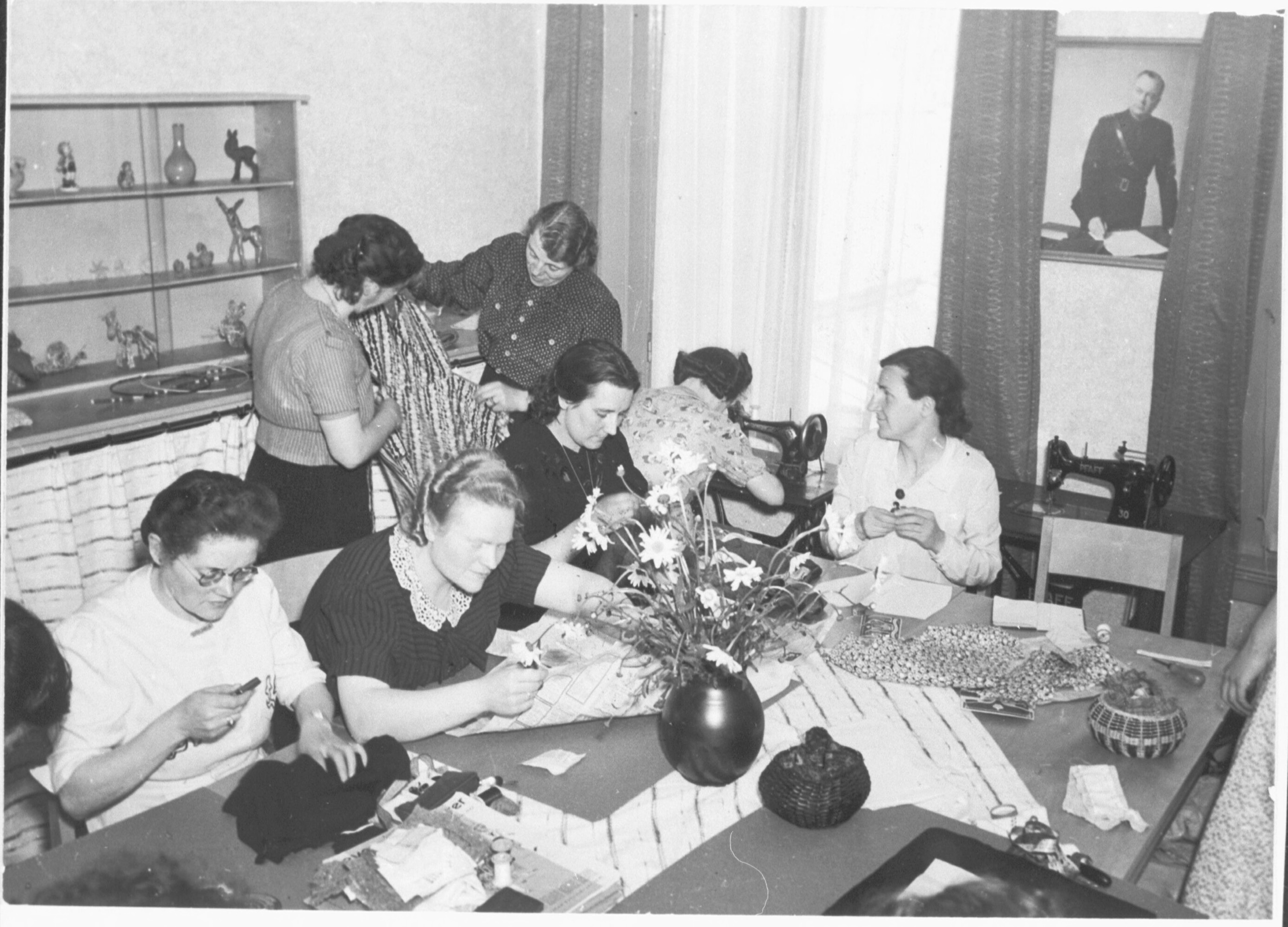 Eerste Moederschool in Arnhem, geopend op 2 mei 1942. Vrouwen tijdens een naai- en verstelmiddag om van oude kledingstukken nieuwe te maken.