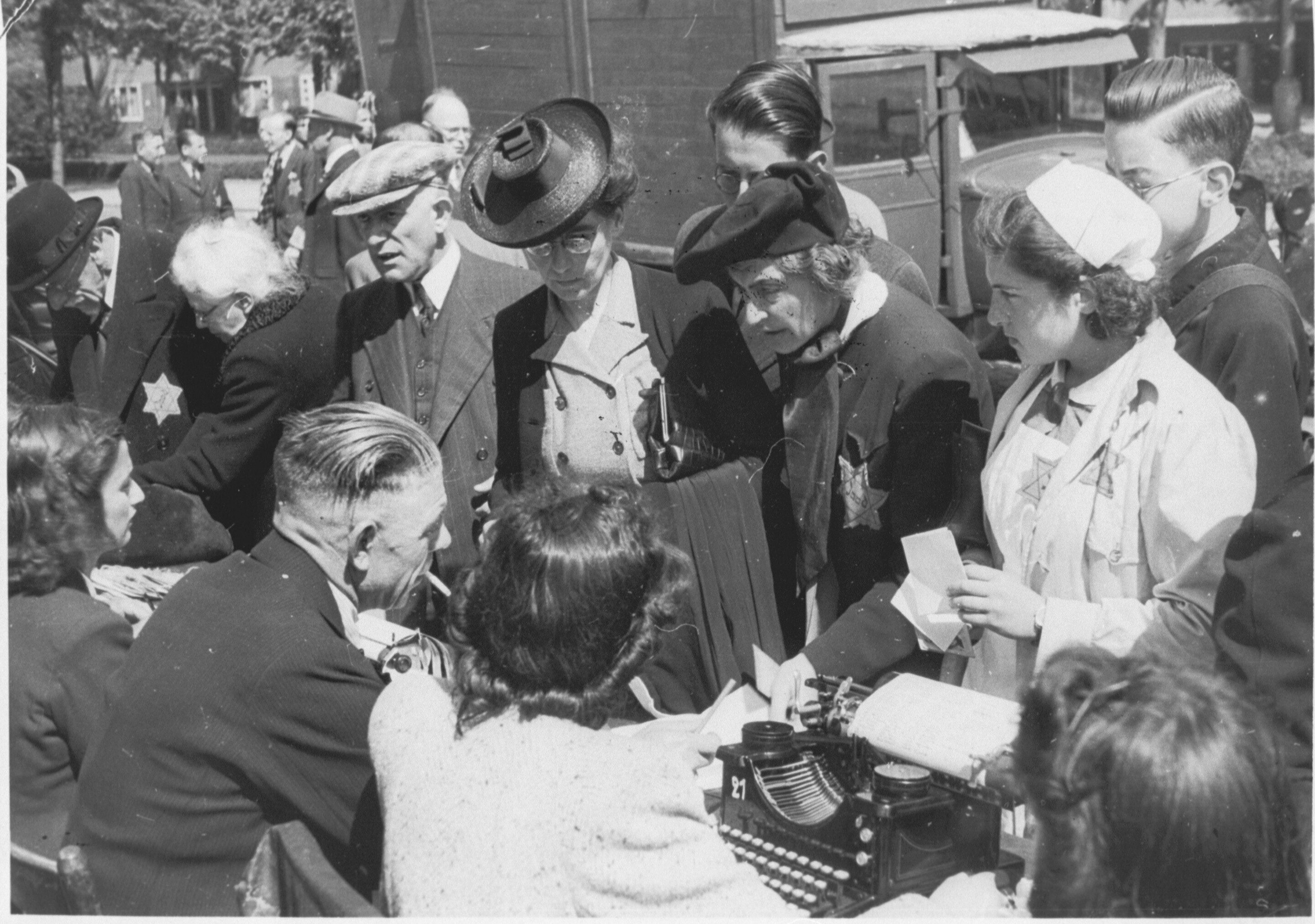 Medewerkers van de kampadministratie van kamp Westerbork schrijven op het Olympiaplein in Amsterdam Joden in op 20 juni 1943