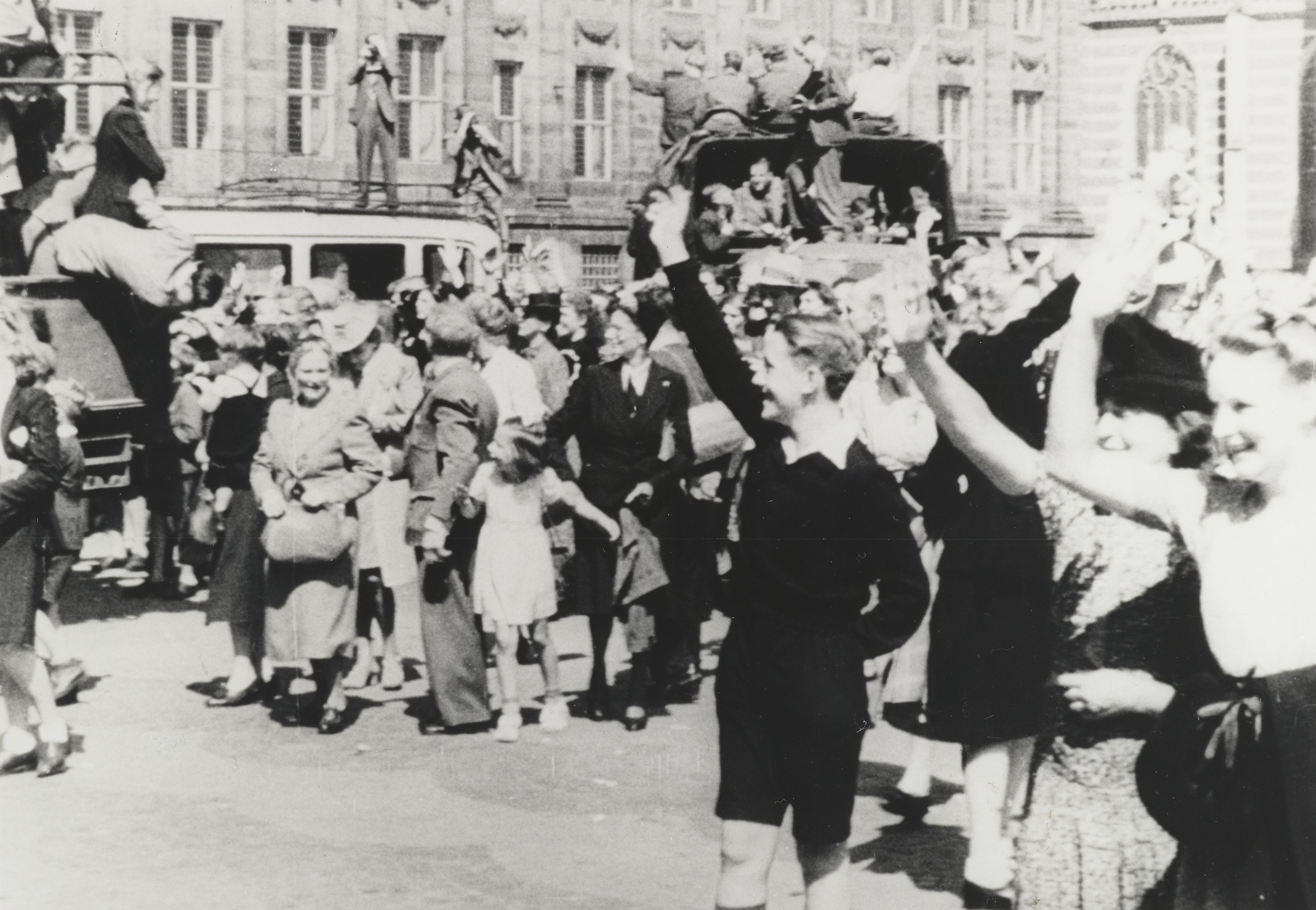 Oorlogsvrijwilligers nemen afscheid op de Dam te Amsterdam voor hun vertrek naar voormalig Nederlands-Indië. De militairen in de vrachtwagens zijn nog in burgerkleding.