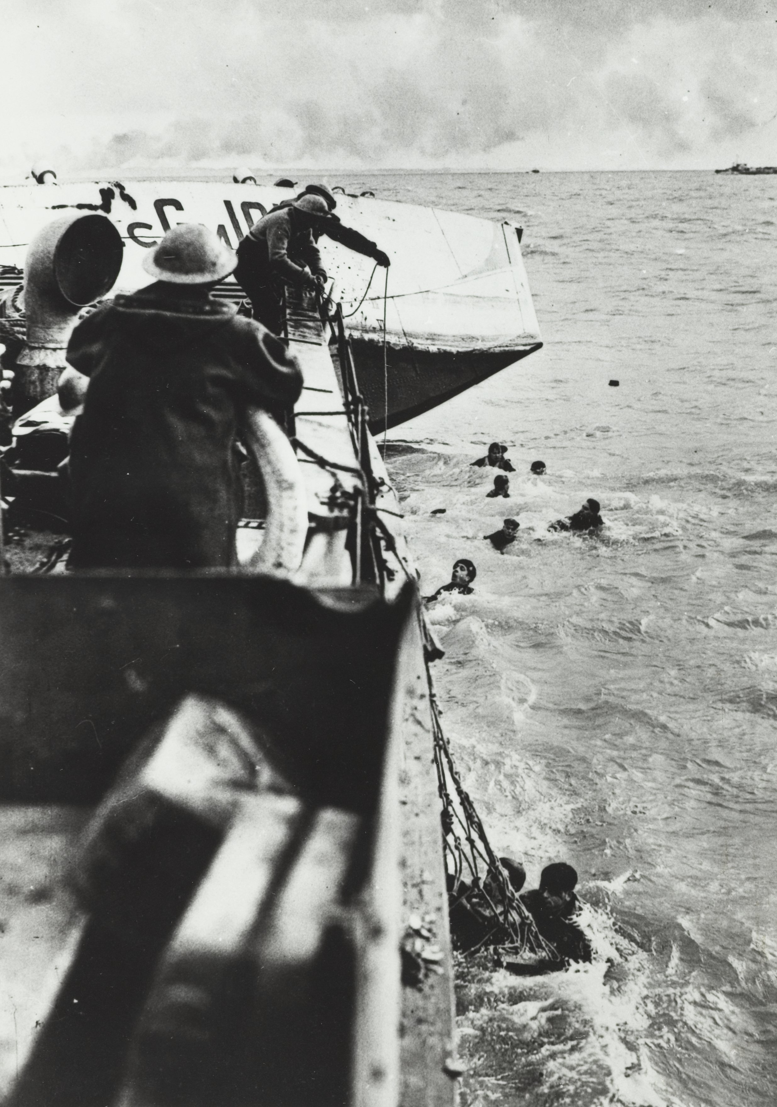 Opvarende commando's van een half gezonken landingsvaartuig worden in de monding van de Westerschelde gered door een reddingsbarkas