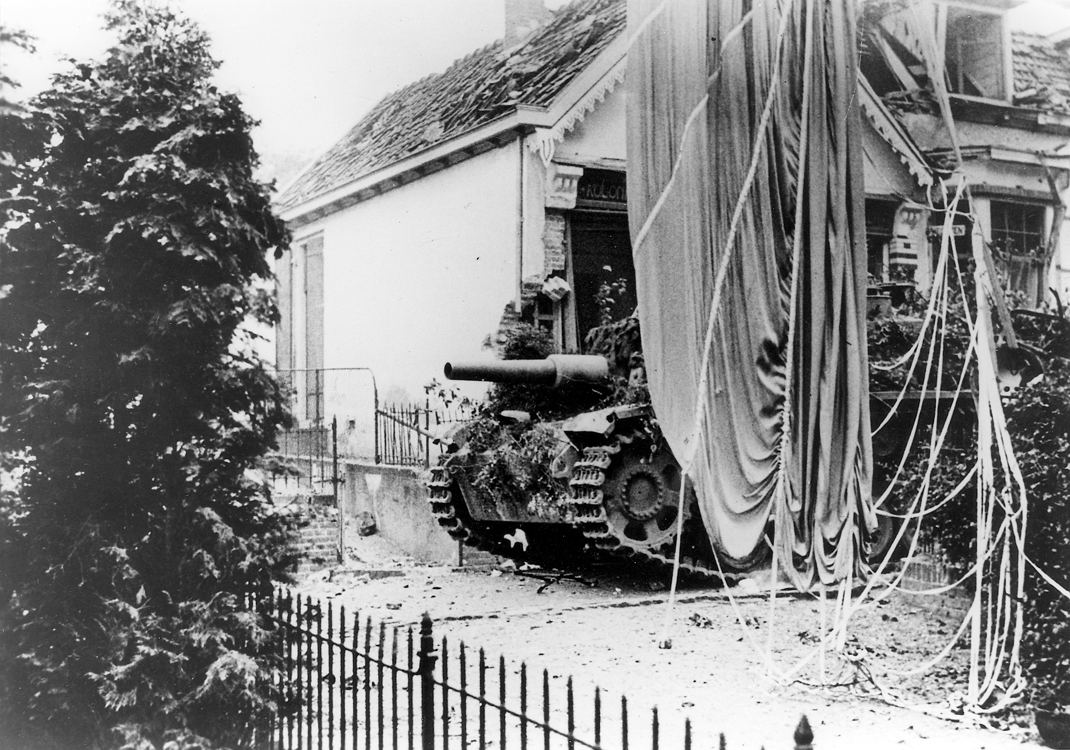 Duits gemotoriseerd geschut op de Weverstraat in Oosterbeek. Rechts de parachute van een Britse bevoorradingscontainer.