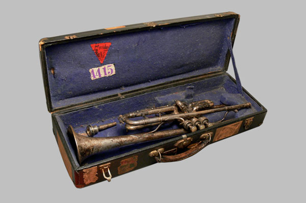 De binnenkant van de trompetkoffer met trompet, in de voering de rode driehoek die Jaap als politieke gevangenen droeg