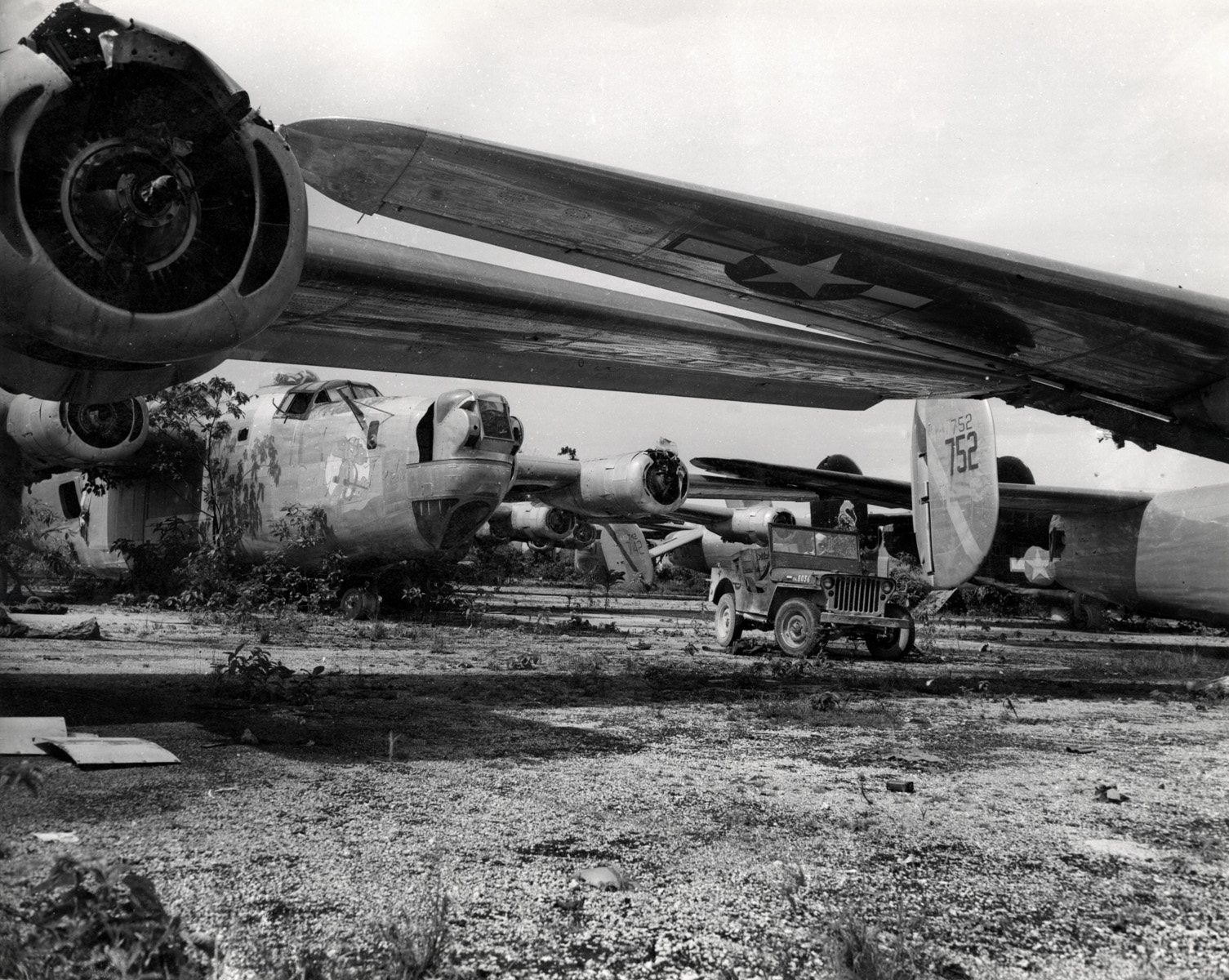 Een militair in een jeep rijdt rond bij een dump van Amerikaanse militaire vliegtuigen op Nieuw-Guinea in 1947.