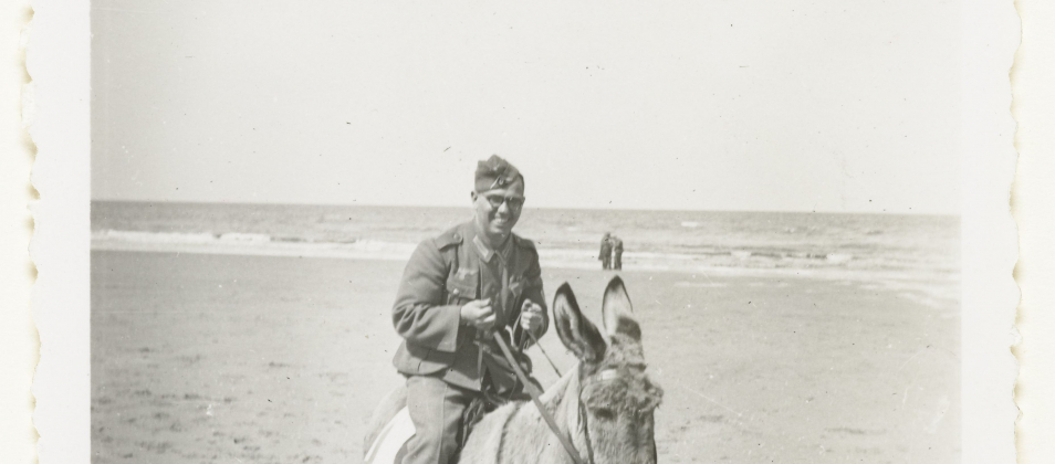 Wehrmacht soldaat rijdt op een ezel aan de Nederlandse kust in 1941