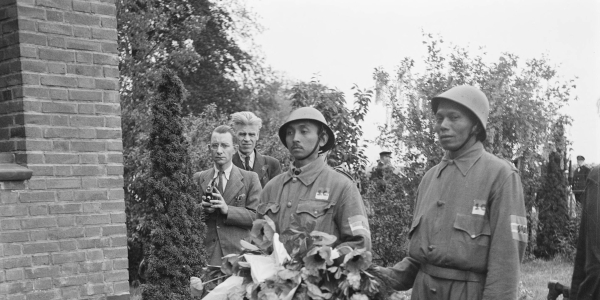 Twee Indonesische leden van de studenten van Groep Irawan van de Binnenlandse Strijdkrachten leggen een krans bij het oorlogsmonument Haagsche Schouw in Leiden op 14 mei 1945. Op de mouw van het uniform is ‘Irawan’ te lezen.